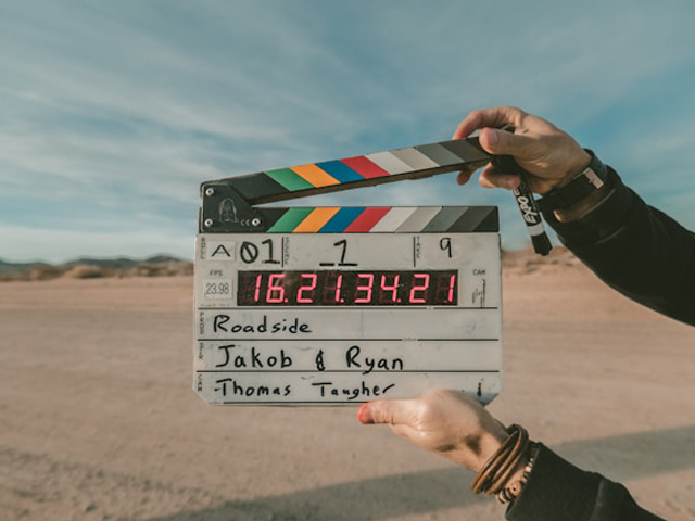 A man holding a movie clapper